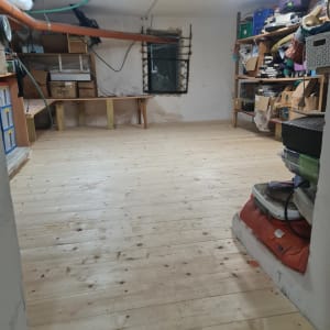 רצפת עץ חדשה בחדר מלאכה עם מדפים