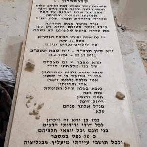 מצבה עם כיתוב בעברית ונרות דולקים