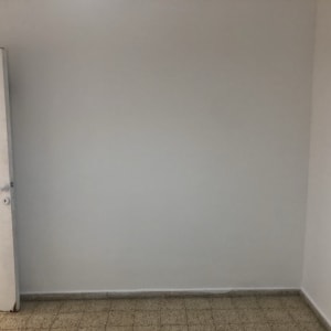 קיר צבוע בלבן עם דלת פתוחה בצד שמאל