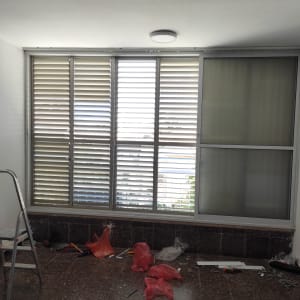 סולם, כלים וציוד תיקון ליד חלון גדול