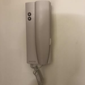 אינטרקום עם שפופרת וכפתורים על הקיר