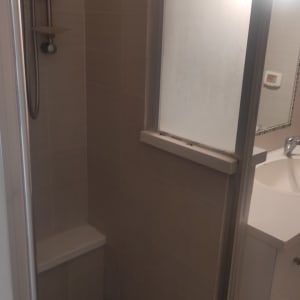 מקלחת עם דלת זכוכית ומקלחת יד