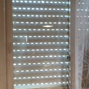 חלון זכוכית עם תריסים סגורים למחצה