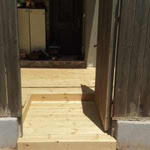 דק עץ חדש עם שער עץ פתוח בכניסה