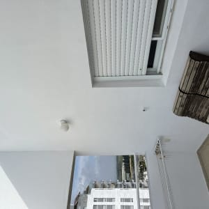 קיר ותקרה צבועים בלבן עם חלון מוגף