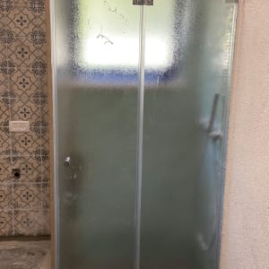 דלת זכוכית למקלחת עם ידית מתכת