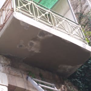 מרפסת עם תיקוני טיח וסולם מתכת