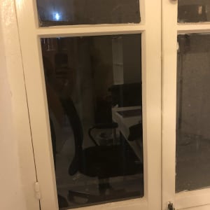 חלון זכוכית עם מסגרת לבנה וידית עגולה