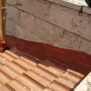 רעפים חומים על גג עם צינור מתכת