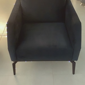 כורסה מרופדת בצבע כהה עם רגליים מעץ