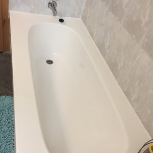 אמבטיה לבנה עם חיפוי קיר שיש וברז כרום