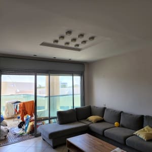 קיר לבן עם סימני צבע, סלון עם ספה אפורה