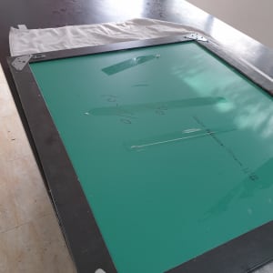 מסגרת מתכת עם לוח ירוק וברגים על שולחן