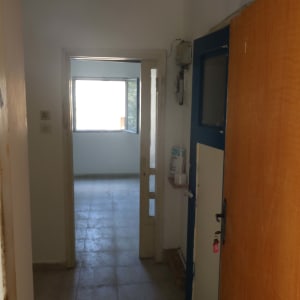 מבואת כניסה וחדר בדירה עם קירות צבועים וריצוף בהיר