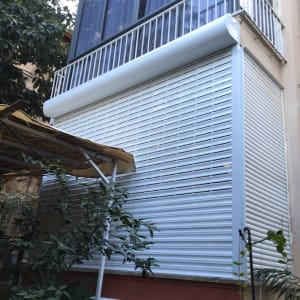 תריסי אלומיניום לבנים על חלון גדול