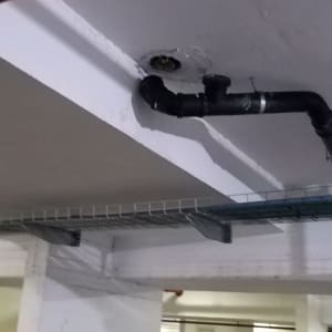 צינור שחור מחובר לתקרה בחניון תת קרקעי