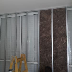 קיר גבס בבנייה עם מסגרת מתכת ולוחות חומים