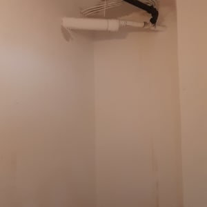 סולם צבוע בצבע לבן ליד קיר עם צינורות