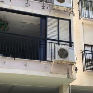 מרפסת עם מסגרת מתכת ומזגן חיצוני