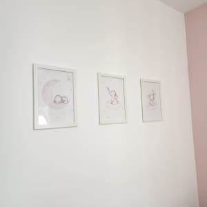 שלושה תמונות ממוסגרות תלויות על קיר לבן