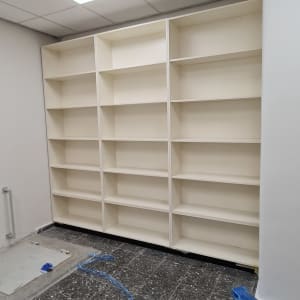 מדפים לבנים מותקנים על קיר בחדר