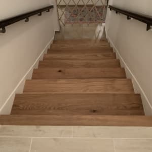 מדרגות עץ עם מעקה מתכת בצדדים