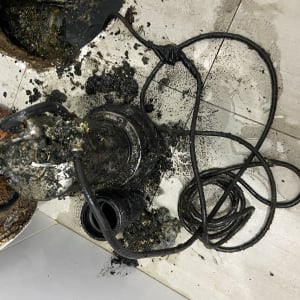 משאבה מלוכלכת עם כבלים על רצפה רטובה