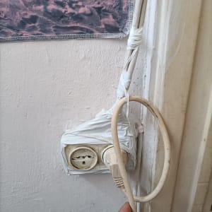 שקע חשמל עם חוטים עטופים בסרט דביק