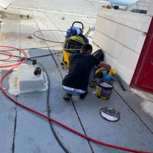 עובד על גג עם דלי וכלי עבודה