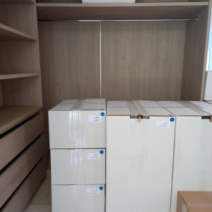 קופסאות קרטון מסודרות בארון עץ עם מדפים