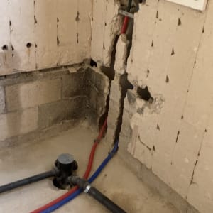 צינורות מים בקיר עם חיבורים ותשתית אינסטלציה