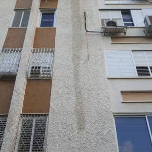 קיר בניין עם סימני רטיבות ואיטום לקוי