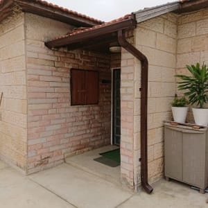 מרזב חום מחובר לגג רעפים אדום