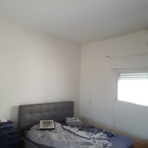 תמונה ממוסגרת מונחת על מיטה בחדר שינה