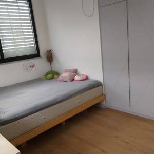 חדר שינה עם מיטה, כריות וארון בגדים