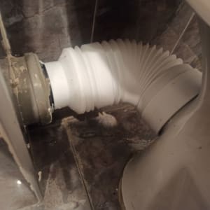 צינור גמיש מחובר לאסלה בחדר אמבטיה