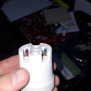 שקע חשמלי עם חוטים חשופים ביד אדם