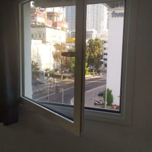 חלון אלומיניום פתוח עם נוף עירוני