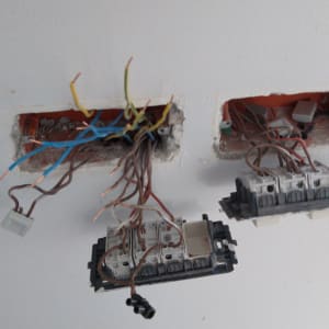 חוטי חשמל חשופים בקיר עם מתגי חשמל