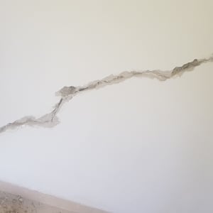 קיר עם סדק גדול ותיקון טיח חלקי