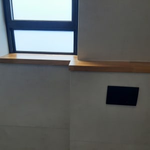 מדף עץ מתחת לחלון עם מסגרת מתכת