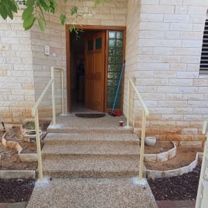 מעקה מתכת ליד דלת כניסה לבית