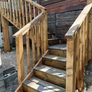 מדרגות עץ עם מעקה ליד מבנה עץ