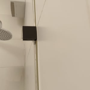 ראש מקלחת, בקבוקי סבון ומראה במקלחת