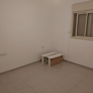 חדר ריק עם קירות לבנים ותאורה עליונה