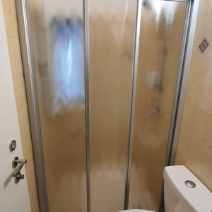 דלתות מקלחת מזכוכית חלבית עם מסגרת מתכת