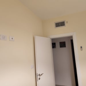 קיר צבוע בצבע בהיר עם דלת פתוחה