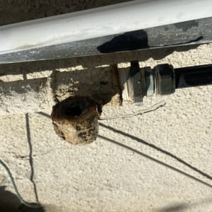 צינור חלוד עם חיבורי מתכת ודליפת מים