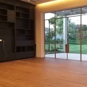 חדר ריק עם רצפת עץ וחלונות גדולים