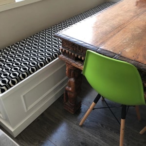 כרית ישיבה עם דוגמה גיאומטרית על ספסל עץ